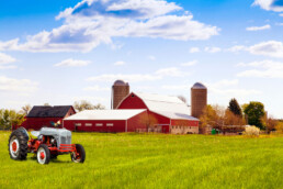 a farm with red barns and a tractor